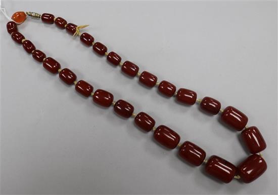 A single strand graduated simulated cherry amber barrel shaped bead necklace, 52cm.